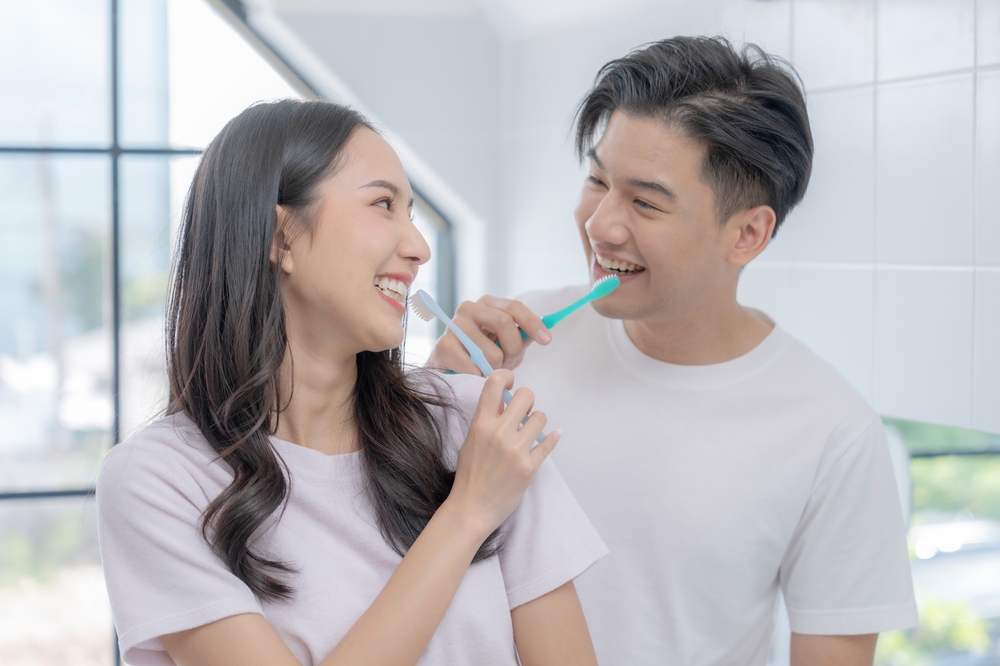 a man and woman brushing their teeth